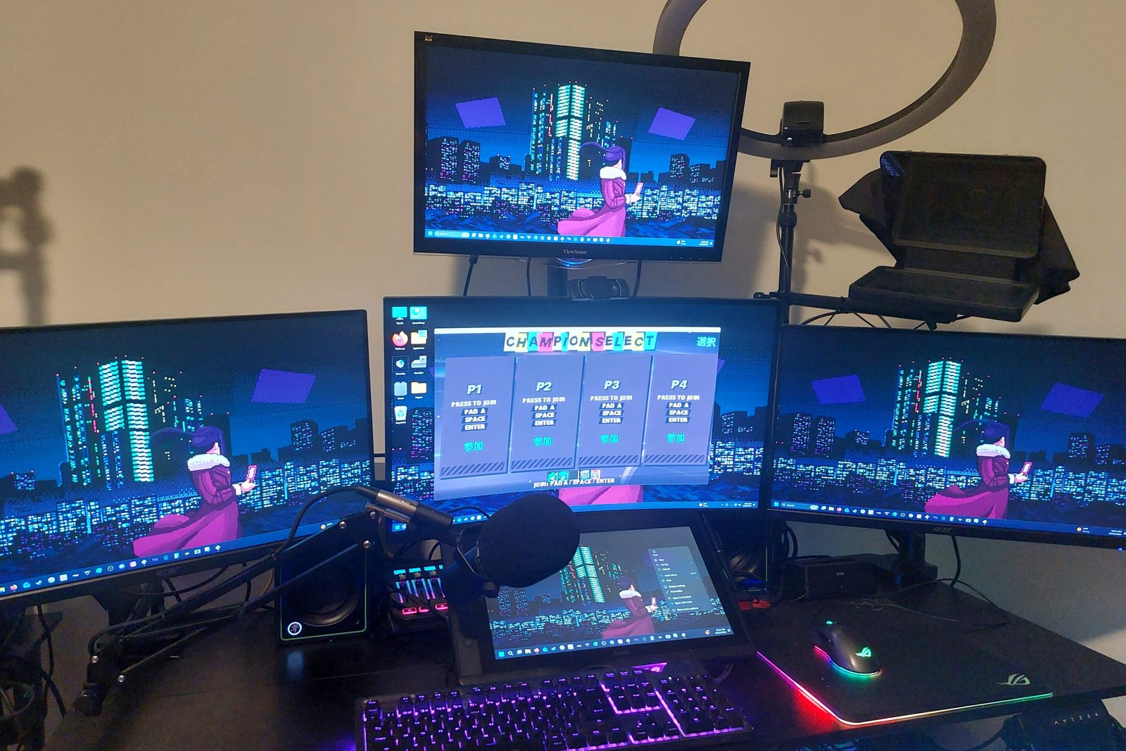 A desk with four monitors running Strikeship Smashers, a microphone, a drawing tablet and a lit PC tower